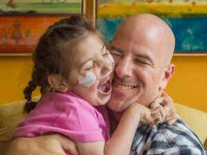 Dad and young daughter hugging and smiling